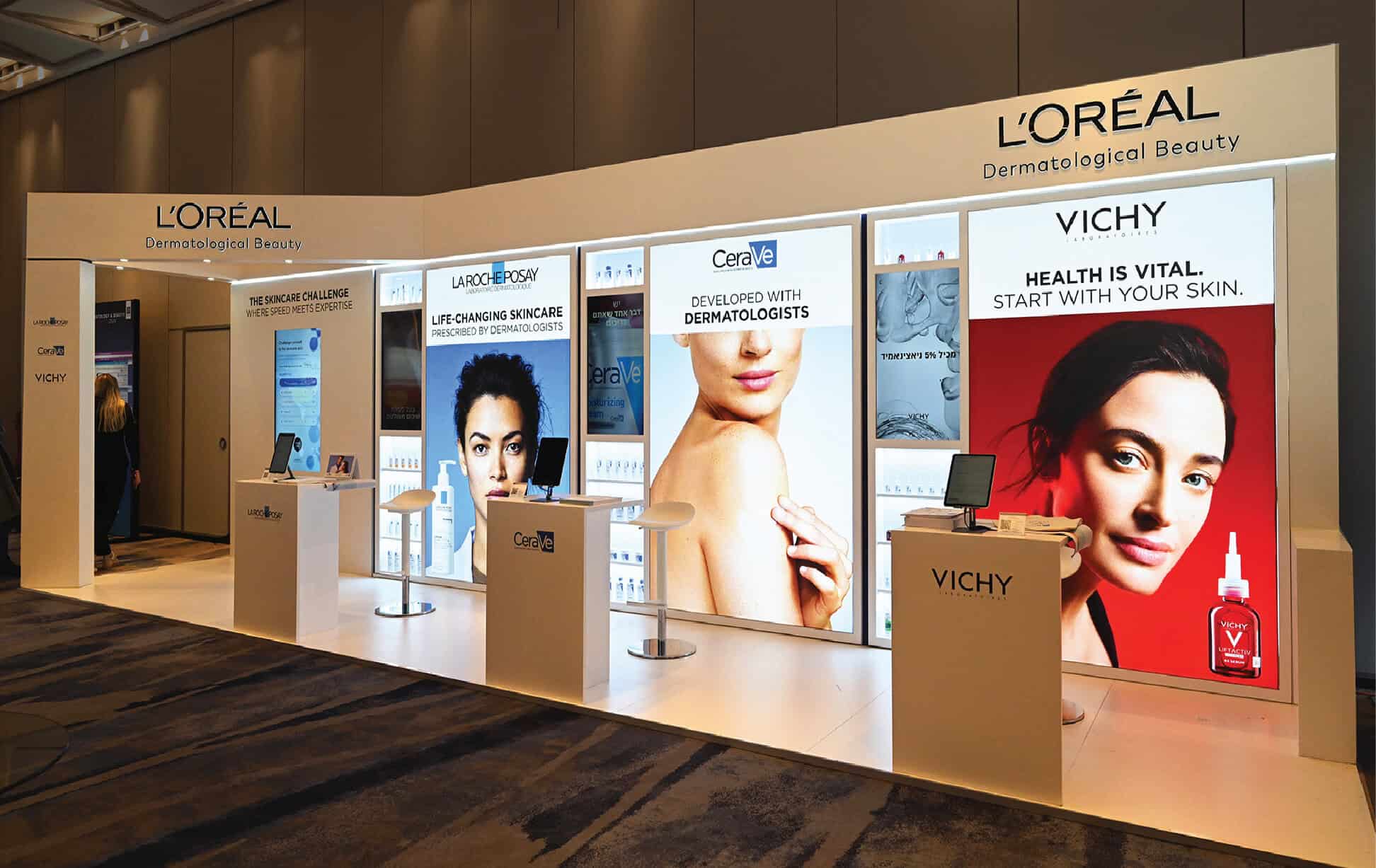 Modern exhibition booth showcasing L'Oréal and Vichy skincare products.