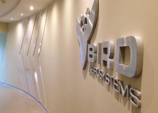 Modern corporate office with 3D logo and sleek design elements.
