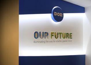 Modern exhibition space with illuminated signage and logo display.