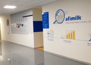 Modern exhibition space with Afimilk branding and informative wall graphics.